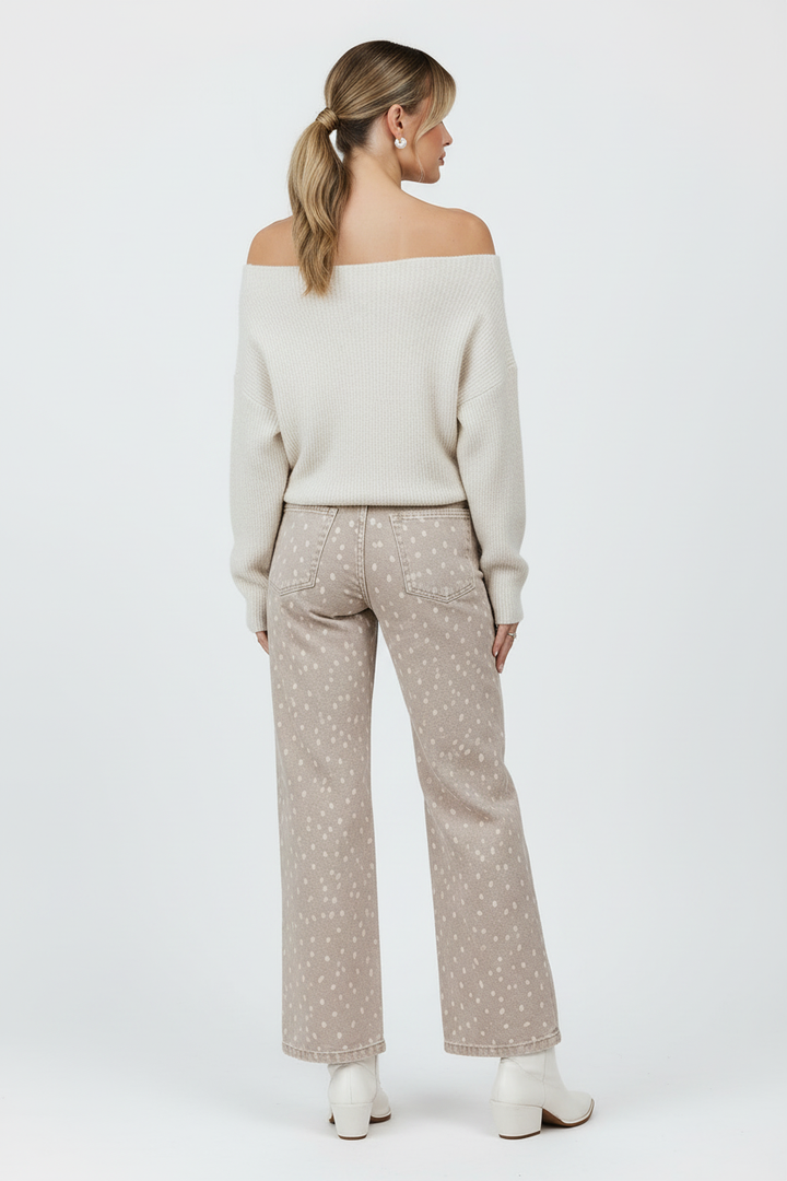 Cream off-shoulder sweater back view with white boots and white background
