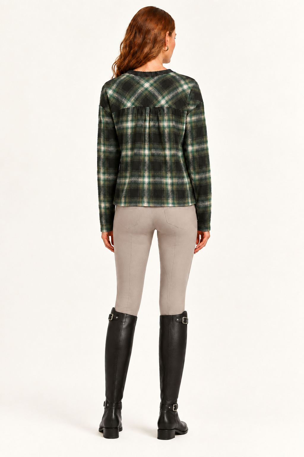 Rowan showing plaid back of charcoal and olive mixed-media sweater with taupe riding pants
