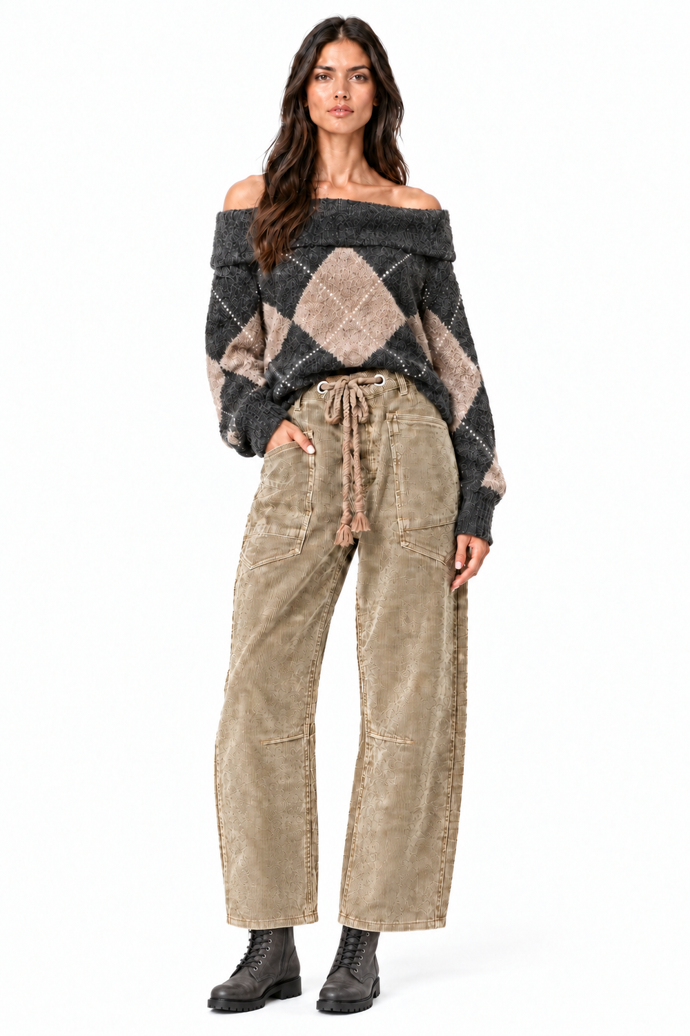 Front view of Beciga brunette model wearing camel corduroy barrel pants with visible braided waist tie, argyle sweater and charcoal combat boots