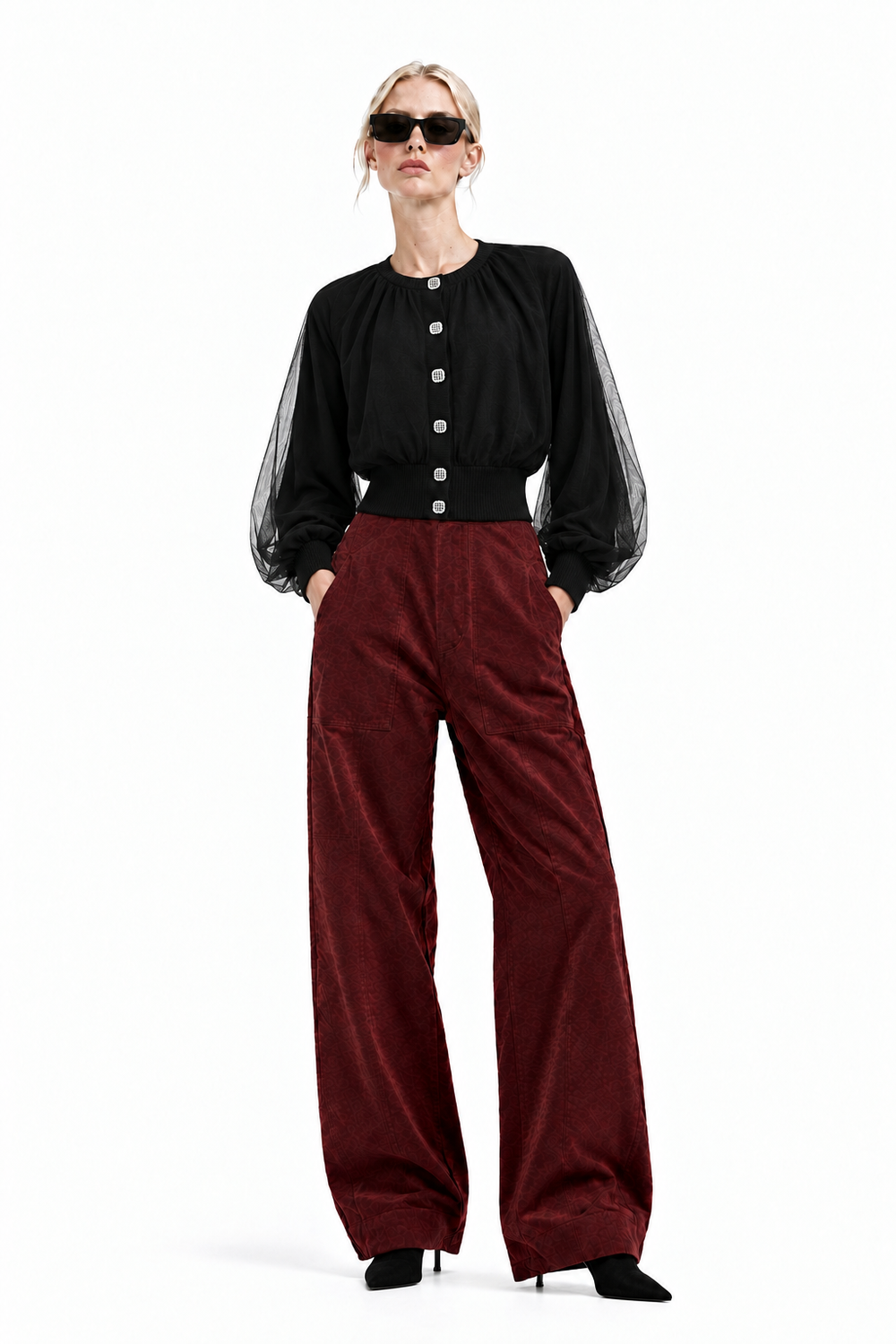 Front view of blonde model wearing Vino corduroy barrel pants with black sheer sleeve top and black ankle boots