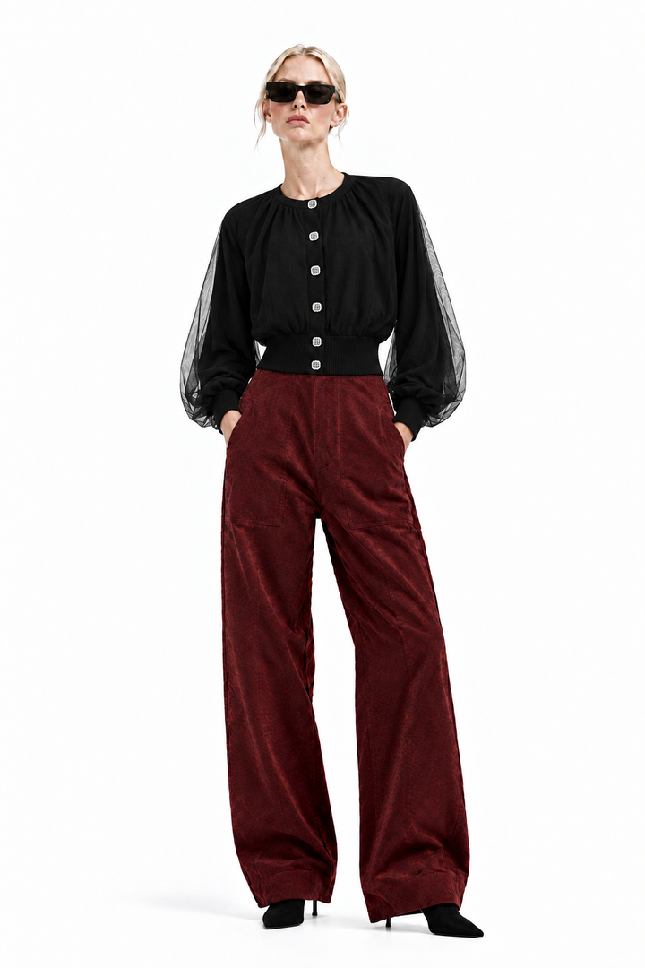 Front view of blonde model wearing Vino corduroy barrel pants with black sheer sleeve top and black ankle boots