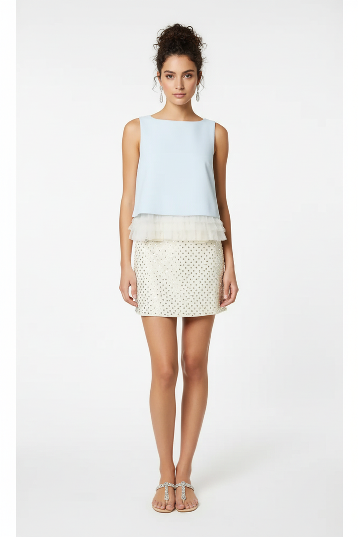 Baby blue sleeveless ruffle hem top - front view with dark curly messy bun model on white background