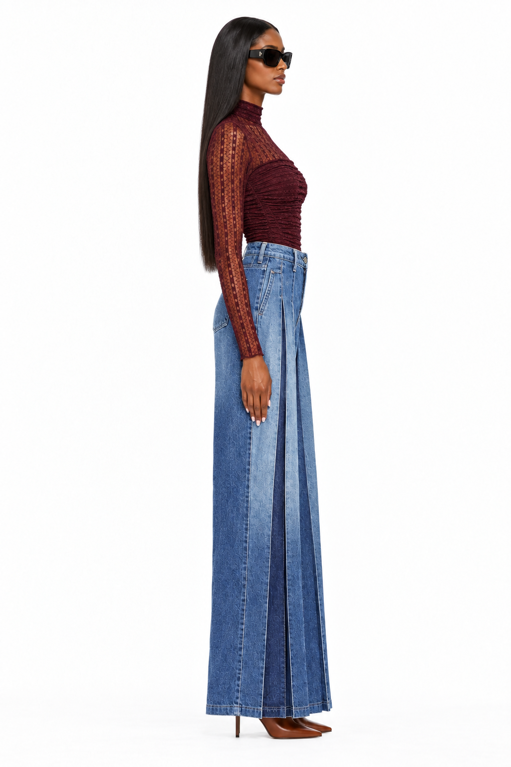 Side view of high-rise dark-wash pleated wide-leg jeans styled with burgundy bodysuit and cognac heels