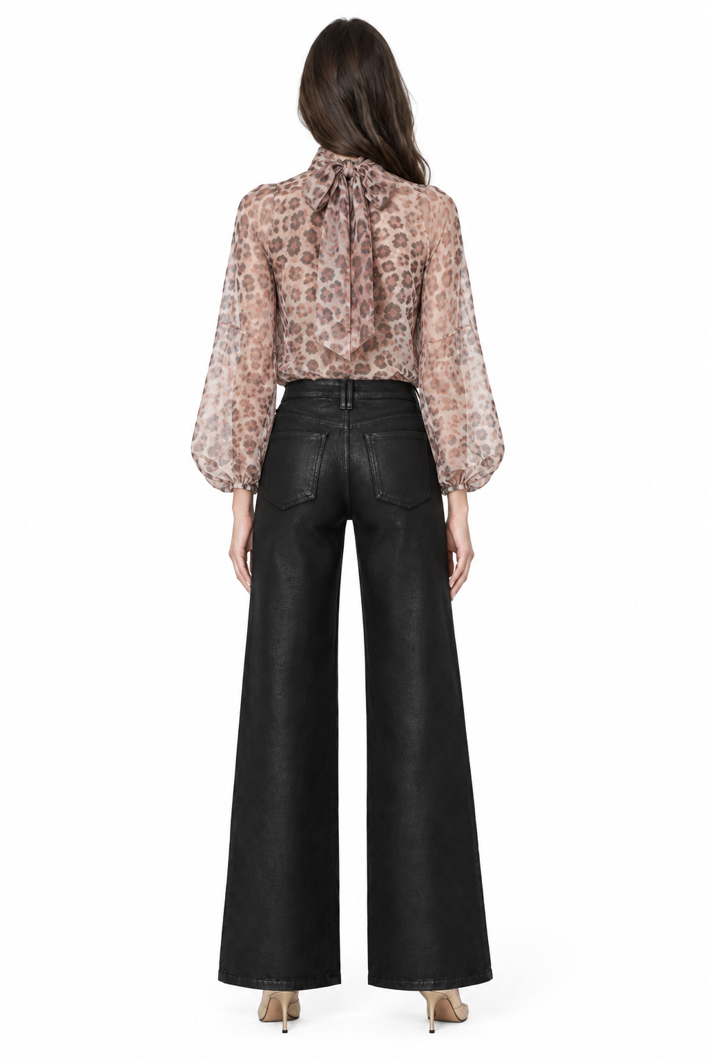 Sloane wearing black coated wide-leg jeans with back patch pockets, printed blouse and gold pumps, back view