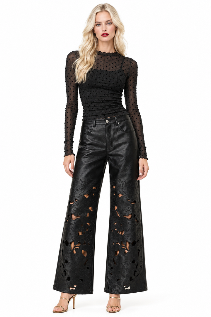 Tiffany wearing black polka-dot sheer top and black vegan-leather floral-cutout wide-leg pants with gold heels, front view
