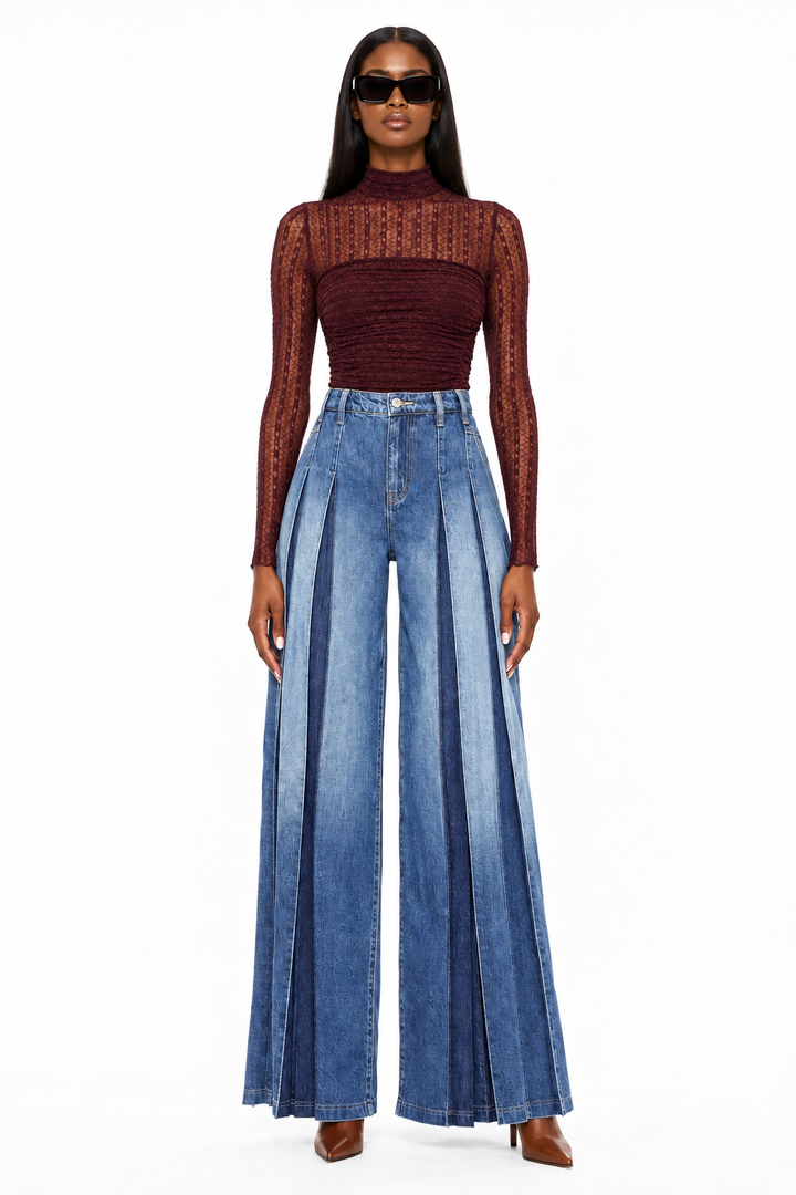 Front view of model in dark-wash high-rise pleated wide-leg jeans, burgundy bodysuit and cognac heels