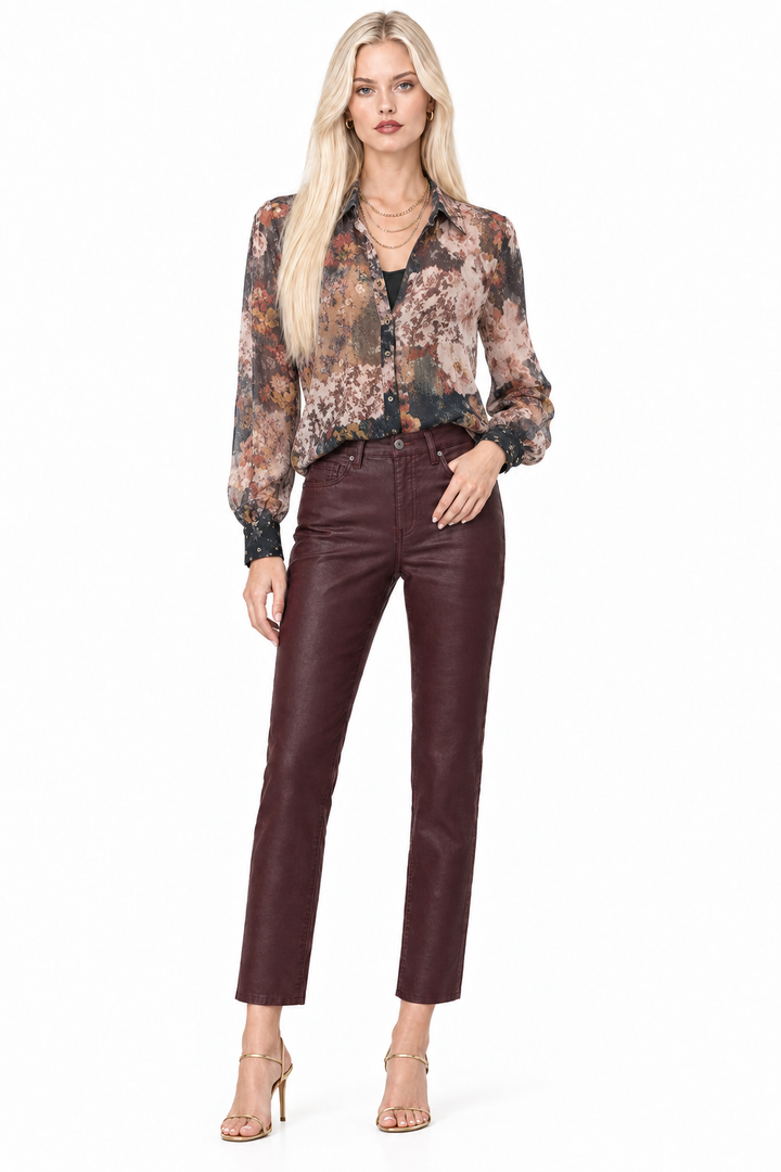 Tiffany wearing deep Winery high-rise slim-straight coated pants with a sheer floral blouse and layered gold necklaces, front view