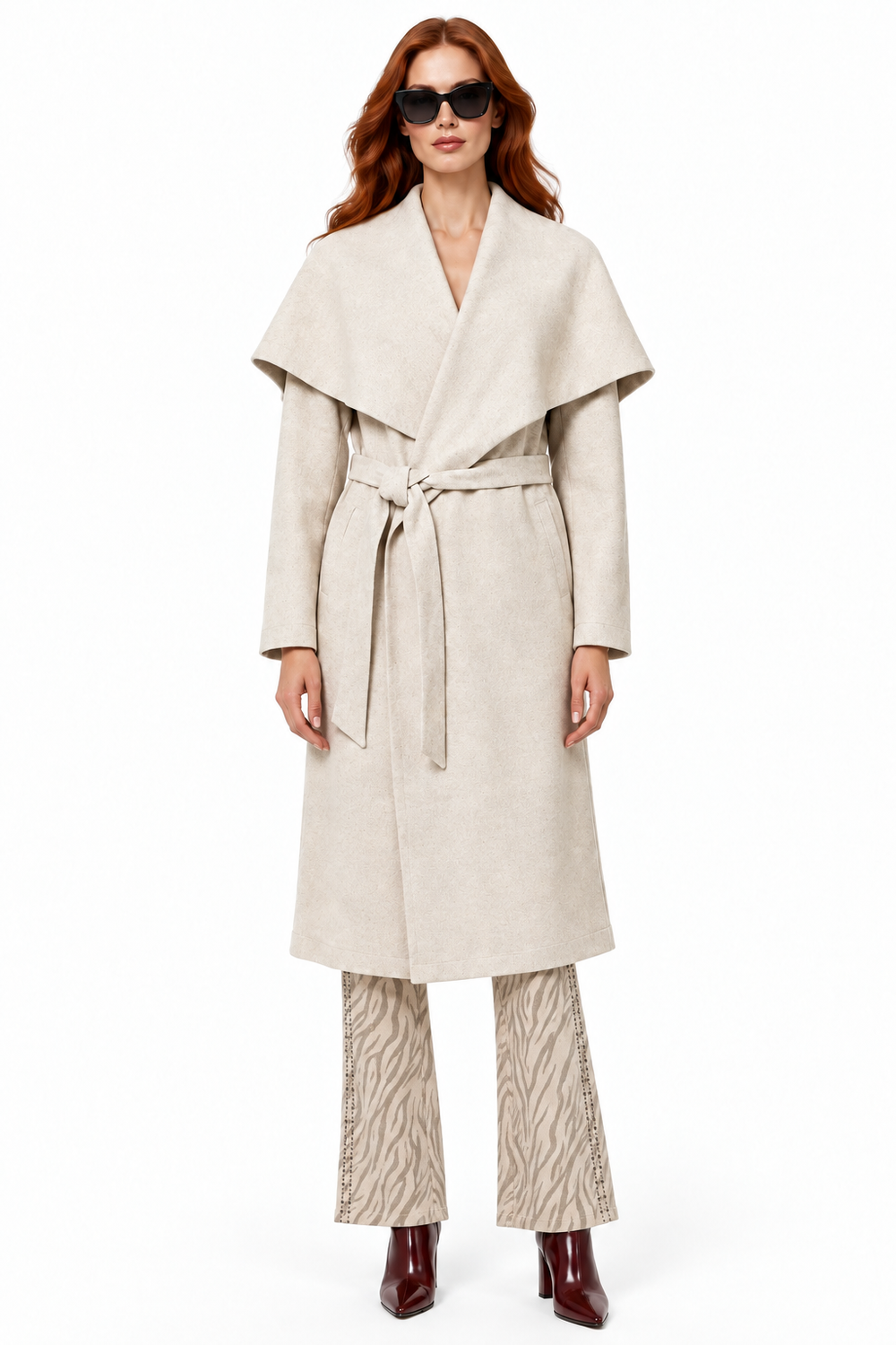 Redhead model wearing oatmeal shawl collar long coat with Beciga zebra print pants and wine ankle boots, front view