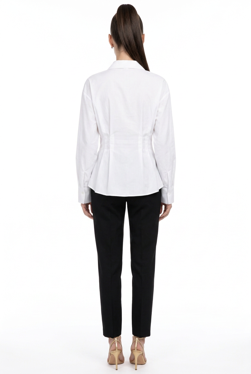 Back view of Sloane wearing the white Pleated Poplin Button Down Top with black trousers and gold heels