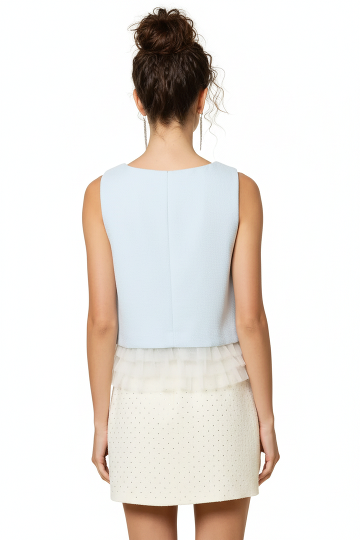 Baby blue sleeveless ruffle hem top - back view with dark curly messy bun model on white background