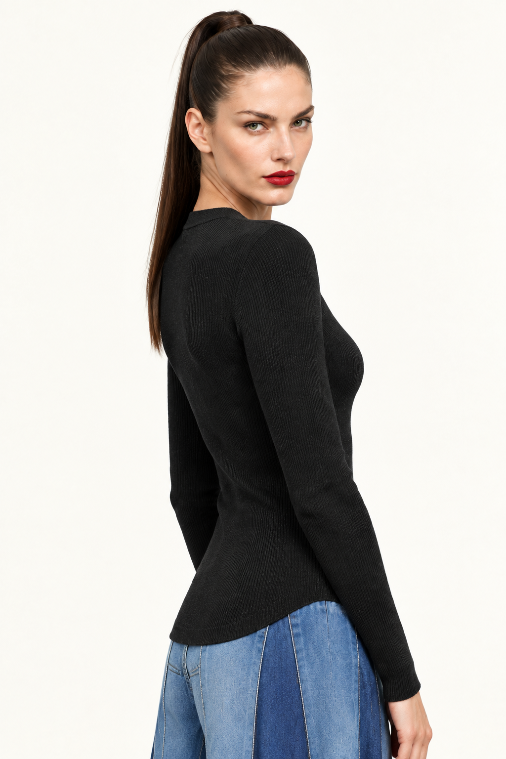 Sloane side waist-up view of black ribbed long sleeve top paired with blue jeans