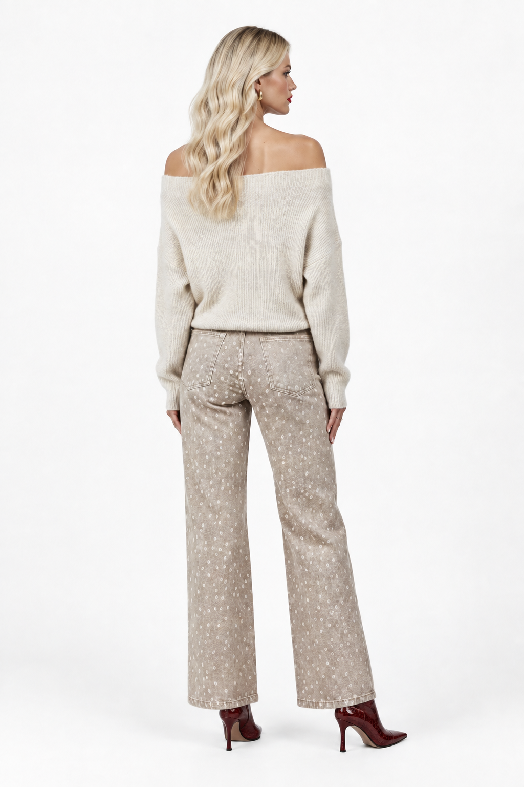 Model in cream off-shoulder sweater and patterned wide-leg pants with dark wine crocodile-embossed boots, back view