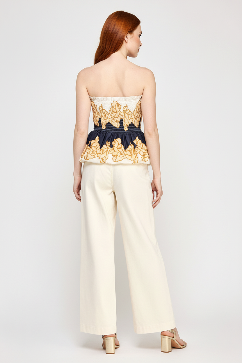 Beciga red hair model wearing navy and cream floral smocked peplum top, back view
