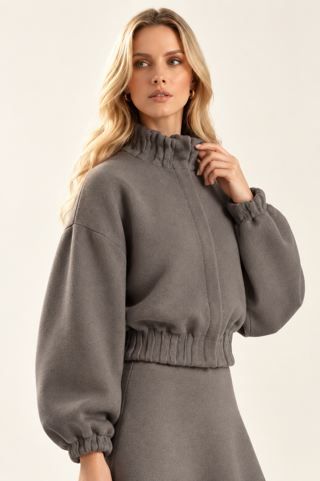Angled view of Maggie in plain Dark Stone knit jacket showing high collar and balloon sleeve
