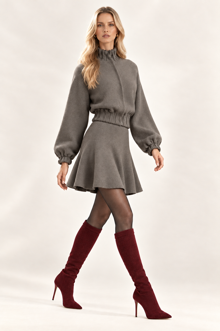 Maggie side view of solid Dark Stone knit skirt and jacket styled with charcoal tights and wine knee-high boots