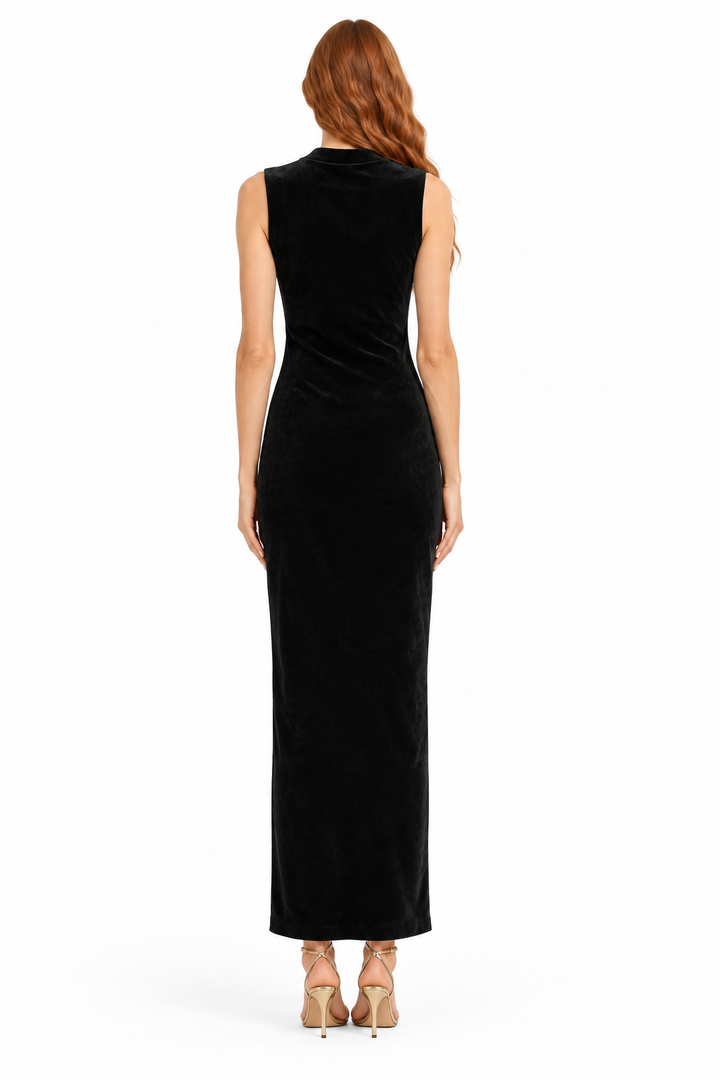 Back view of black sleeveless velvet maxi dress on redhead Beciga model with gold strappy heels