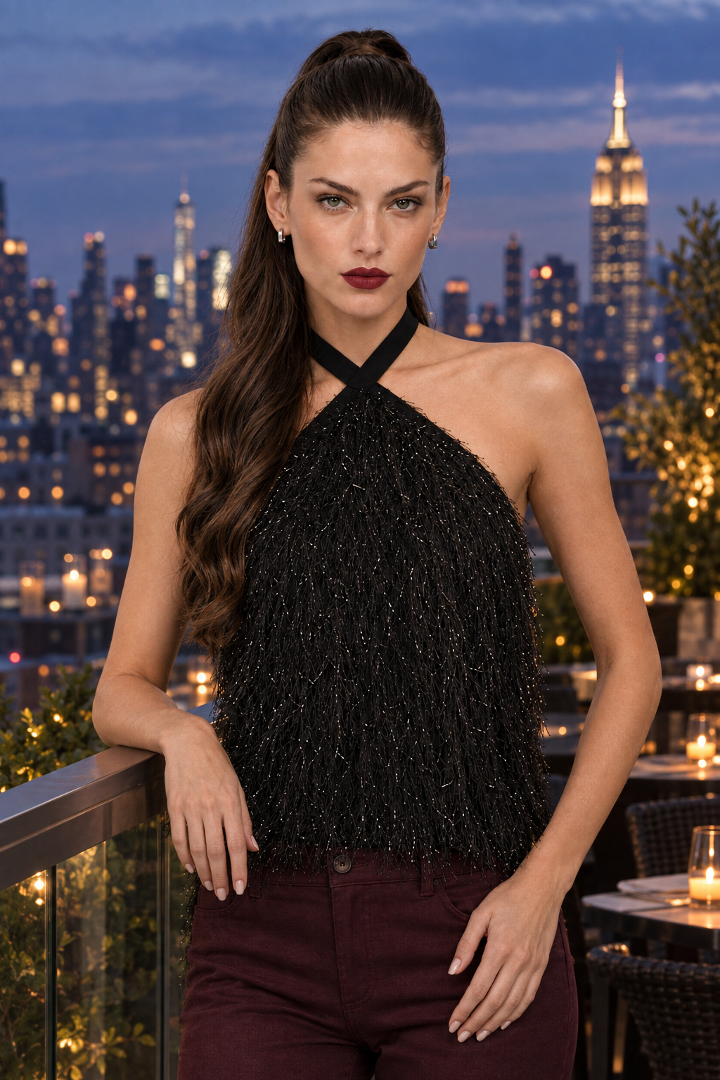 Sloane wearing black crisscross feather-like fringe halter top and wine pants at a New York rooftop restaurant