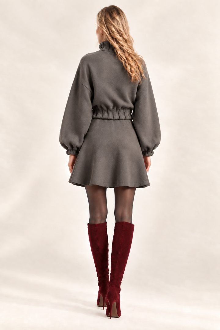 Back view of Maggie wearing solid Dark Stone knit flare bottom skirt and matching jacket with wine boots