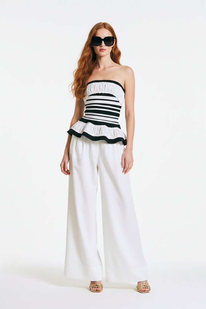 Beciga red hair model wearing white and black striped strapless peplum top, full length shot