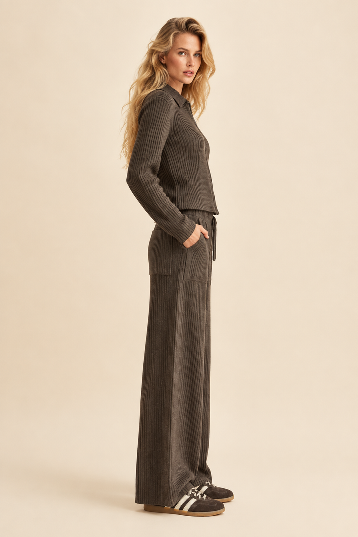 Side view of Tricia in Espresso ribbed knitted pants and brown striped sneakers