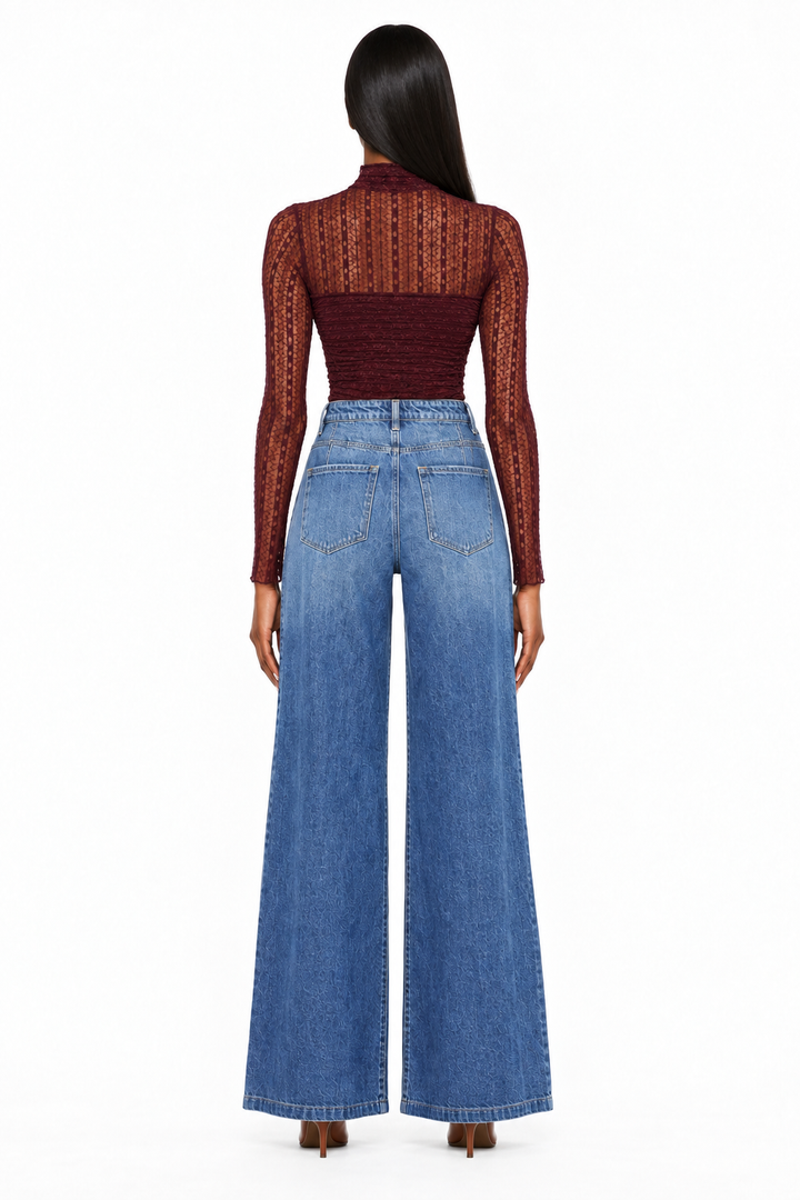 Back view showing pockets and wide legs of dark-wash high-rise jeans on model with burgundy bodysuit
