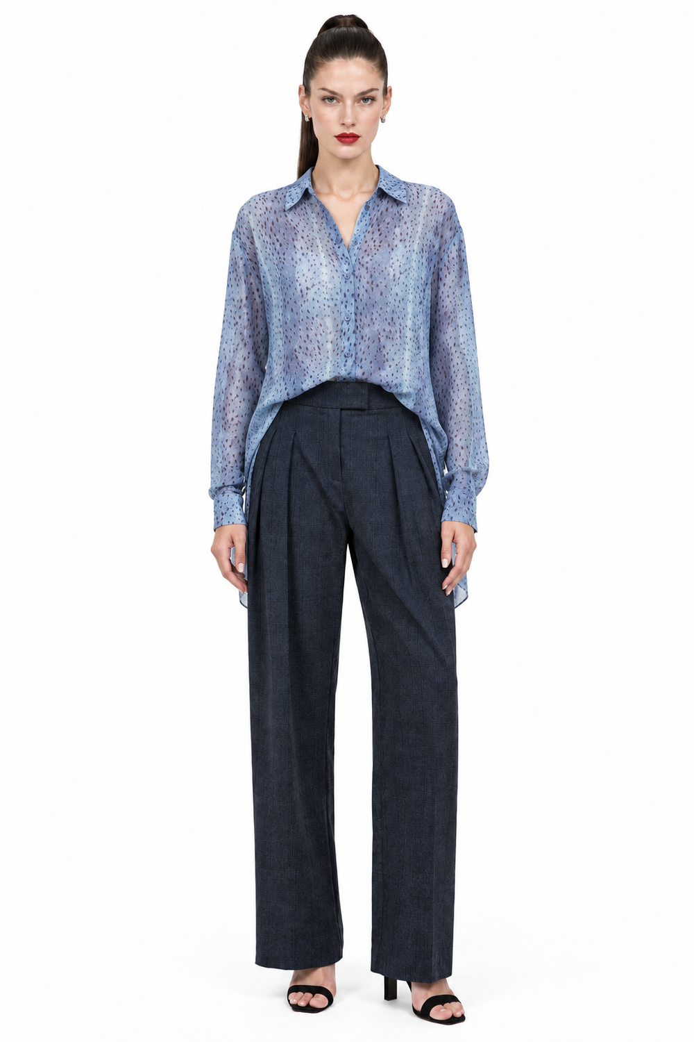 Sloane wearing navy pleated plaid straight-leg trousers with blue printed blouse, front view