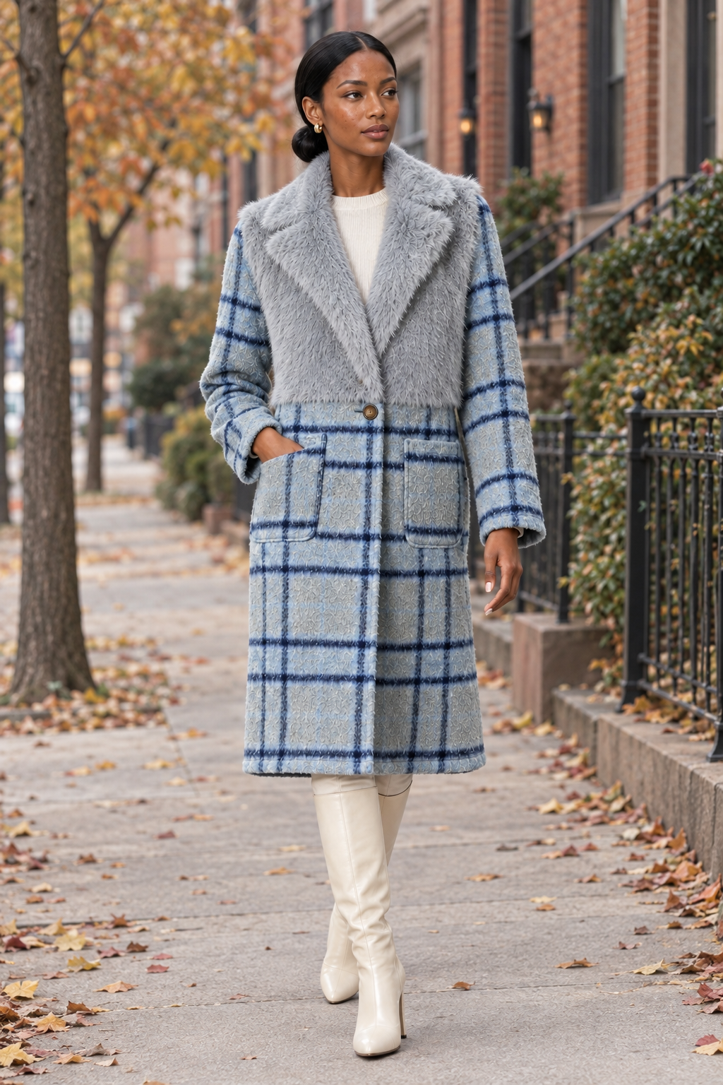 Model wearing cloudy blue faux-fur and plaid coat with cream knee-high boots on a fall neighborhood sidewalk